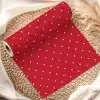 Red Wrapping Paper With White Polka Dots, Rolled And Partially Unfurled On A Woven Mat.