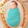 Sleeping Baby Swaddled In A Teal Polka Dot Wrap, Inside A Wicker Basket.