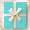 Teal Gift Box With White Polka Dots And A Beige Ribbon.