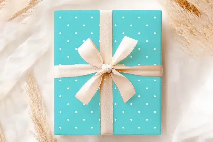 Teal Gift Box With White Polka Dots And A Beige Ribbon.