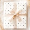 A White Gift Box With Black Polka Dots And A Beige Ribbon.