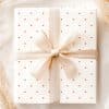 A Gift Box With A Beige Ribbon And Red Polka Dots.