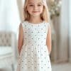 A Young Girl Wearing A White Polka Dot Dress.