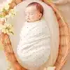 Sleeping Baby Swaddled In A White Polka Dot Blanket Inside A Wicker Basket.