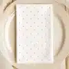 A White Napkin With Light Purple Polka Dots Sits On A Beige Plate.