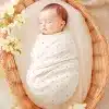 Sleeping Baby Wrapped In A Pink Polka Dot Swaddle Blanket Inside A Wicker Basket.