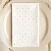 White Napkin With Light Pink Polka Dots On A Beige Plate.