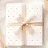 A Gift Box With A Light Beige Ribbon And A Pink Polka Dot Pattern.
