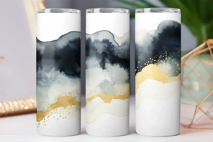 Three white tumblers with abstract gray, black, and gold designs.