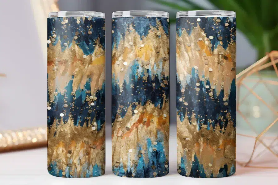 Three tumblers with an abstract design featuring teal, gold, and dark blue paint strokes and gold glitter.
