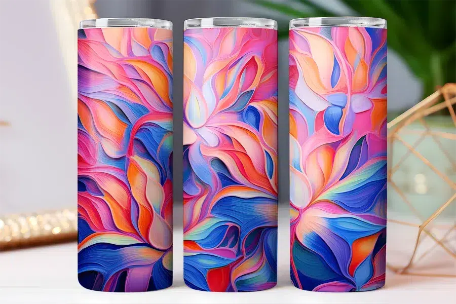Three colorful tumblers with an abstract floral design in shades of pink, blue, and orange.