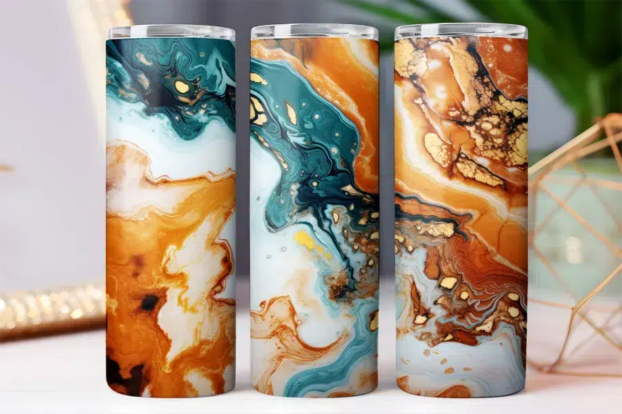 Three tumblers with an abstract marble design in teal, orange, and gold.