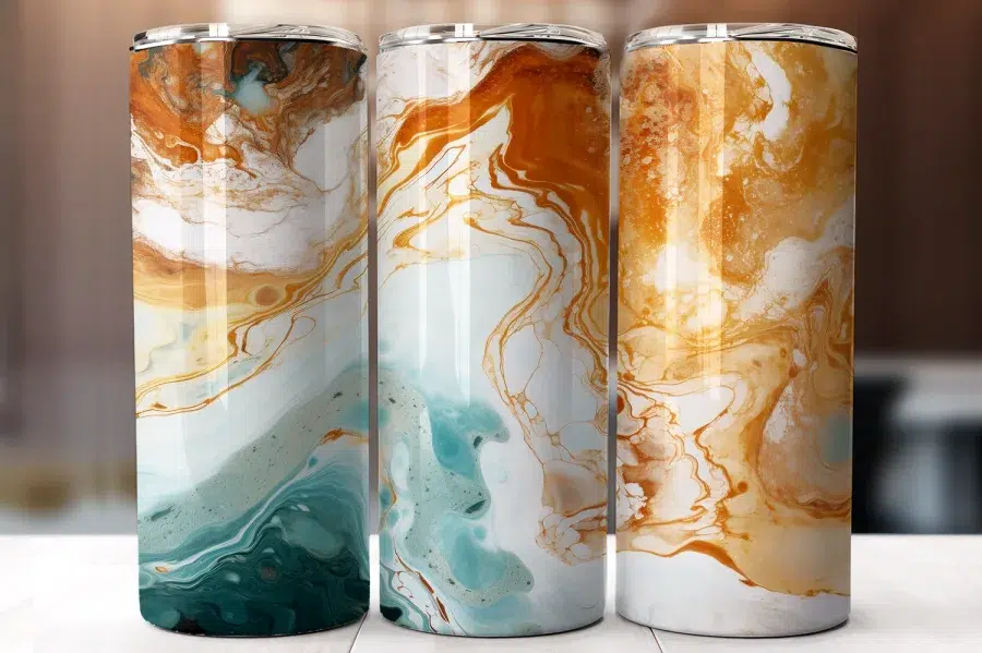 Three Tall Tumblers With An Abstract Marble Design In Shades Of Teal, Gold, And White.