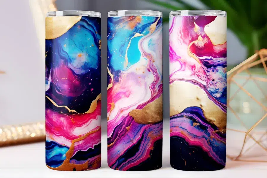 Three tumblers with an abstract pink, blue, purple, and gold marble design.