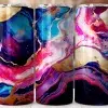 Three Tumblers With Abstract Pink, Blue, Purple, And Gold Marble Designs.