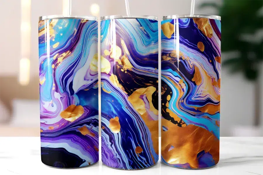 Three Stainless Steel Tumblers With A Blue, Purple, And Gold Marble Design.
