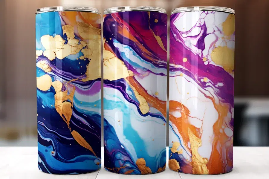 Three Stainless Steel Tumblers With Abstract Marble Designs In Shades Of Blue, Purple, And Orange With Gold Accents.
