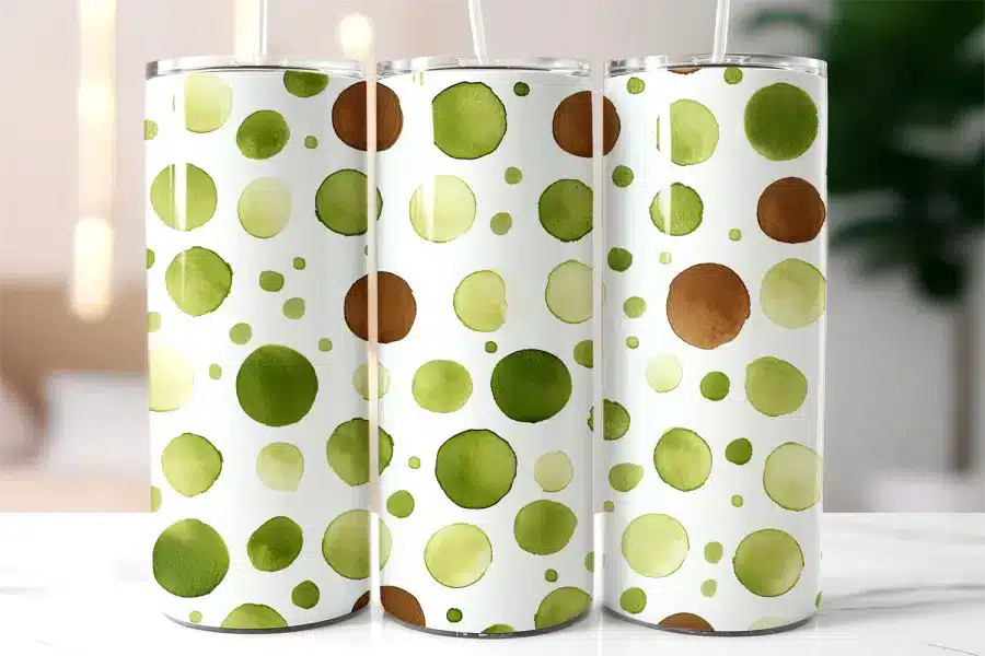 Three Stainless Steel Tumblers With A Watercolor Dot Pattern In Shades Of Green And Brown.