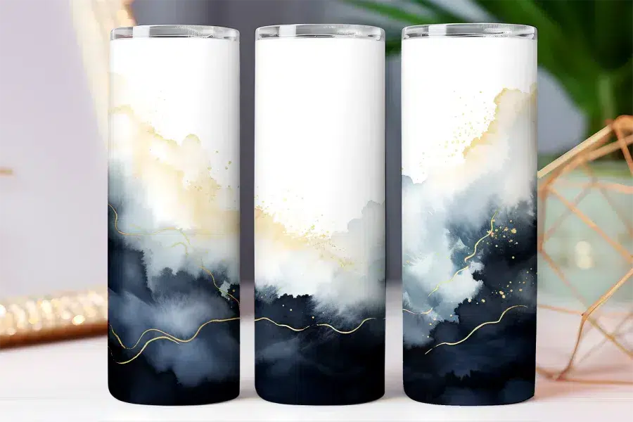 Three tall tumblers with an abstract design of blue, white, and gold watercolor washes.