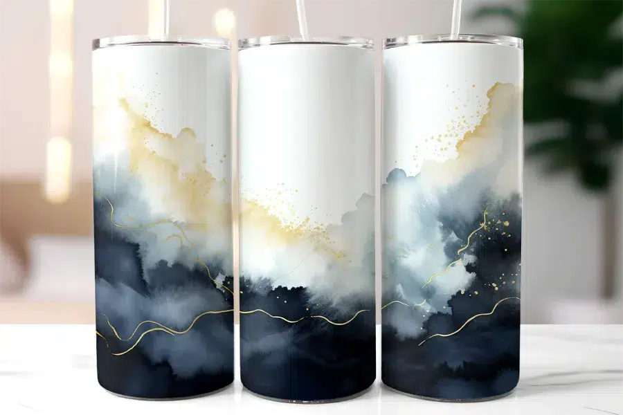 Three Tumblers With Abstract Watercolor Designs In Shades Of Blue And Gold.