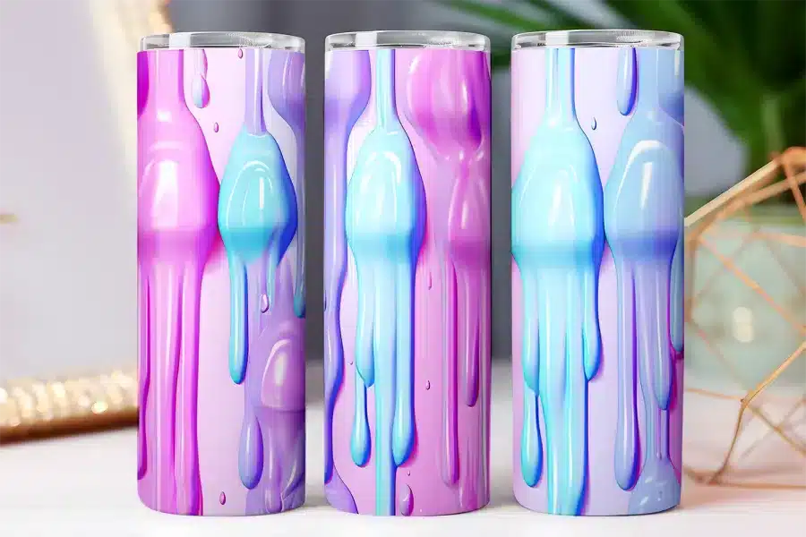 Three pastel-colored tumblers with a dripping paint design.
