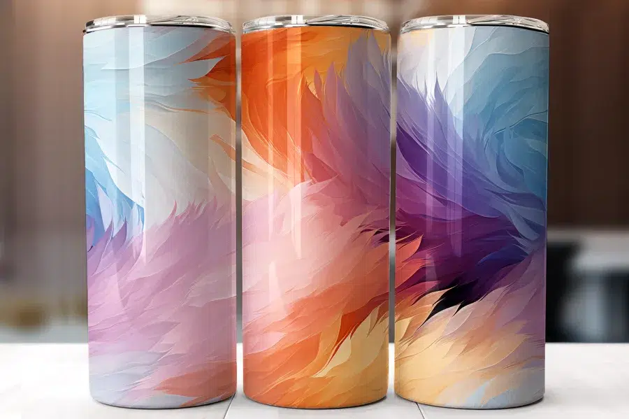 Three Stainless Steel Tumblers With Abstract Feather Designs In Pastel, Orange, And Purple Hues.