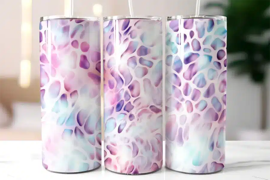 Three Pastel Purple And Blue Patterned Stainless Steel Tumblers With Straws.