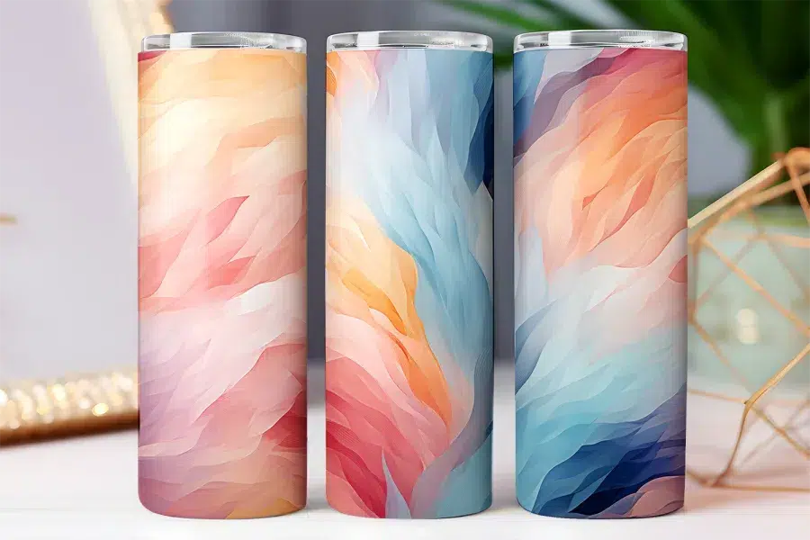 Three tall tumblers with abstract swirling pastel designs.
