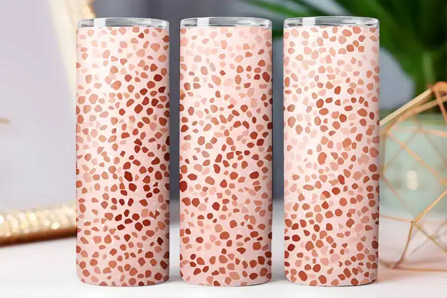 Three pink and terracotta tumblers with a speckled pattern.