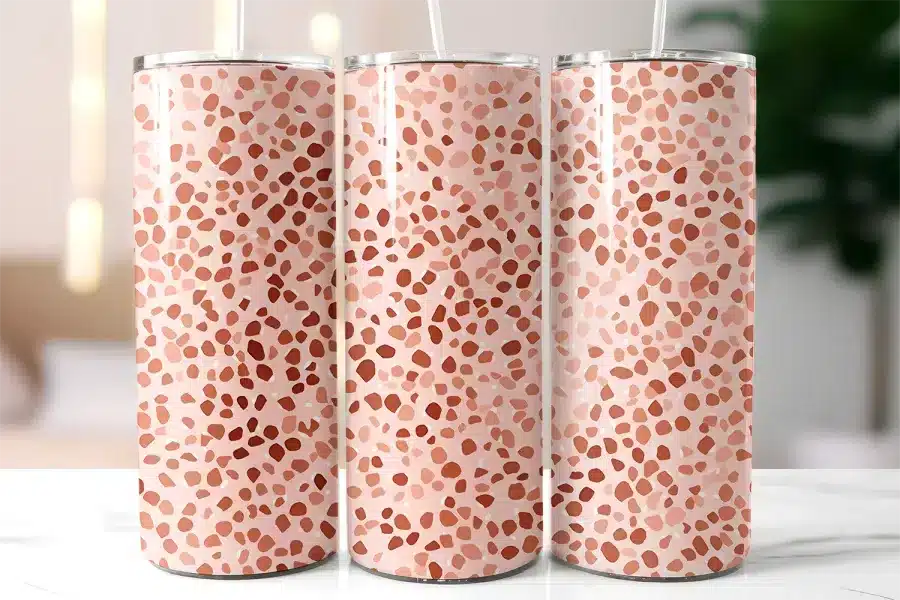 Three Pink And Terracotta Patterned Tumblers With Straws.