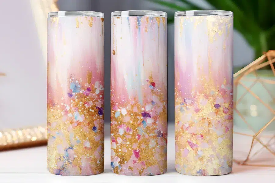 Three tall tumblers with an abstract pink, gold, and white design.
