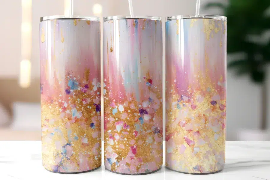 Three Pastel Pink And Gold Tumblers With Straws.