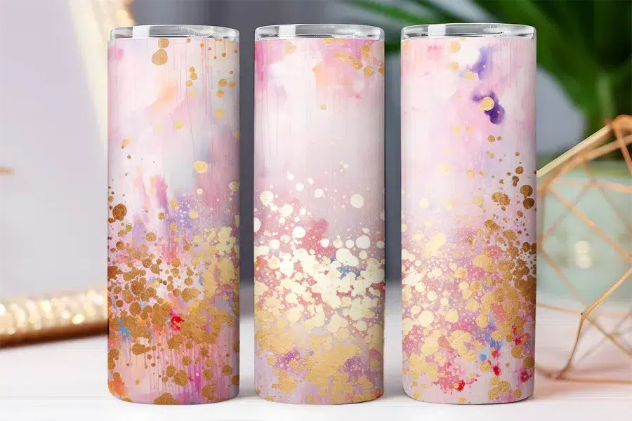Three pink and gold tumblers with an abstract watercolor design.