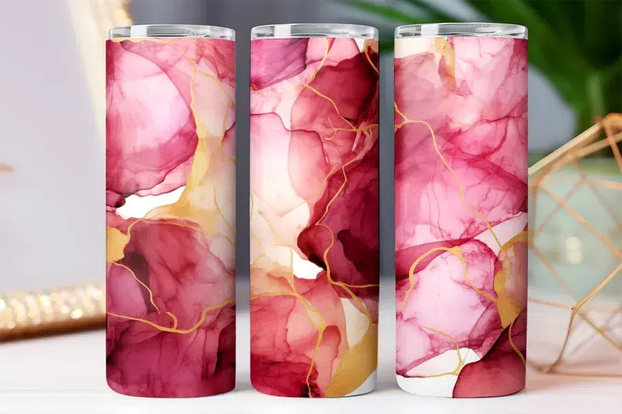 Three tumblers with an abstract design featuring pink and gold marble-like swirls.
