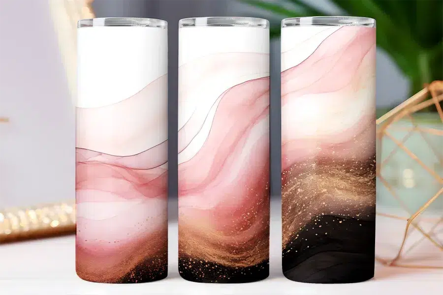 Three tall tumblers with an abstract design featuring pink, gold, and black marble swirls.
