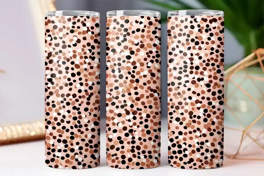 Three tumblers with a pink background and a pattern of brown, black, and white polka dots.