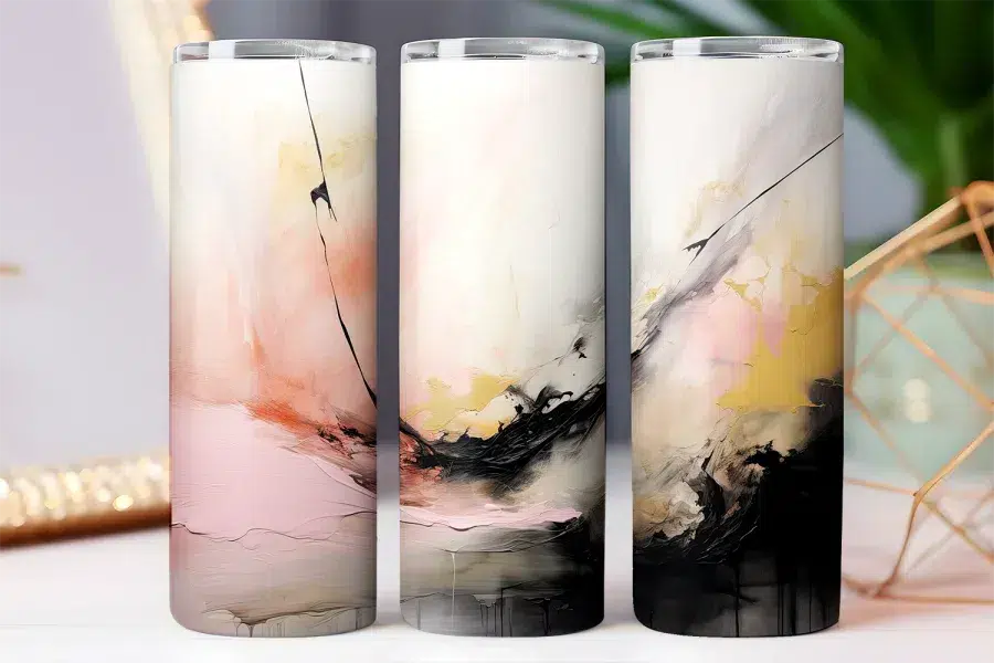 Three tall tumblers with abstract art designs in pink, black, and gold.