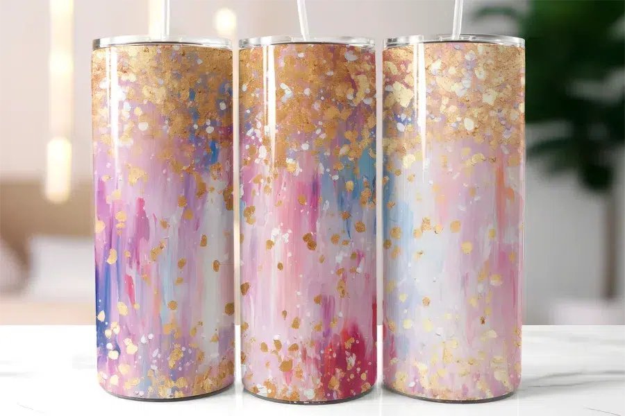 Three Pastel Pink And Gold Tumblers With Straws.