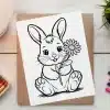 A Coloring Page Featuring A Cute Bunny Holding A Flower.