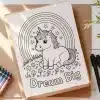 A Coloring Page Featuring A Cute Unicorn Sitting Under A Rainbow, Surrounded By Flowers, With The Words Dream Big Below.