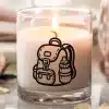 A Lit Candle In A Glass Jar With A Backpack And Water Bottle Design.