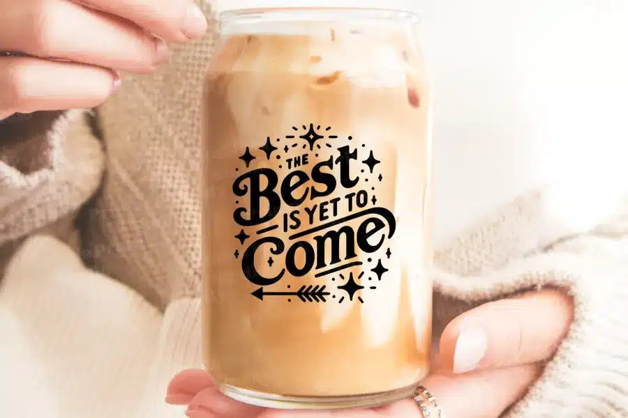 A Glass Jar Filled With Iced Coffee, Displaying The Text The Best Is Yet To Come.