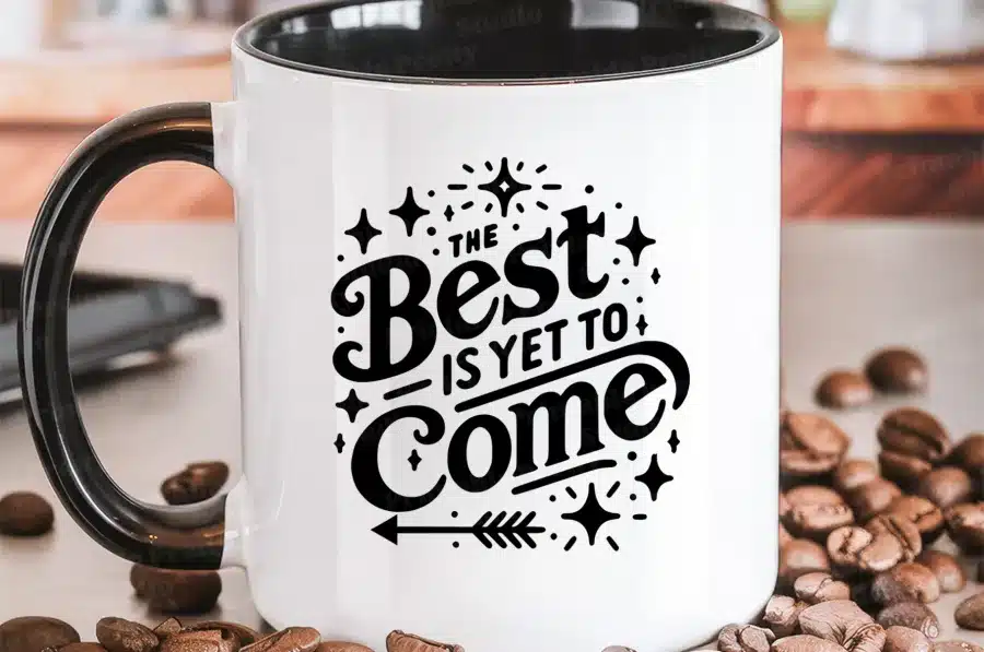White Coffee Mug With A Black Handle, Displaying The Text The Best Is Yet To Come In A Stylized Font With Decorative Elements.