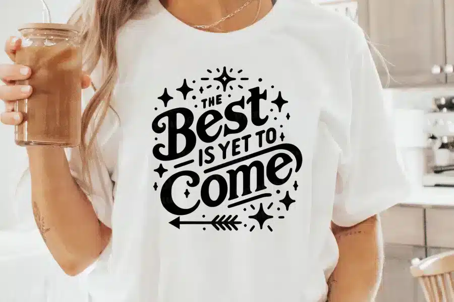 Woman wearing a white t-shirt with a black design that says The Best is Yet to Come.