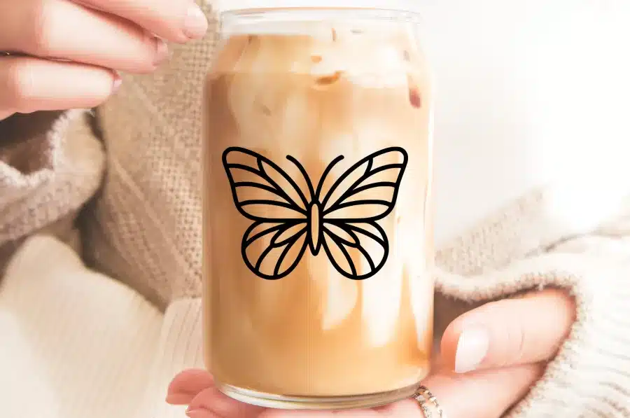 A Glass Iced Coffee With A Butterfly Design.