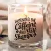 A Lit Candle In A Clear Glass Jar With The Text Running On Caffeine And Dry Shampoo.