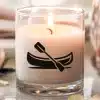 A Lit Candle In A Clear Glass Jar Features A Canoe And Paddle Design.
