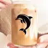 A Person'S Hands Holding A Glass Jar Filled With Iced Coffee, Featuring A Black Dolphin Silhouette On The Side.