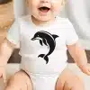 Baby Wearing A White Bodysuit With A Black Dolphin Graphic.