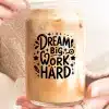 A Person'S Hands Holding A Glass Iced Coffee Can With The Text Dream Big Work Hard.
